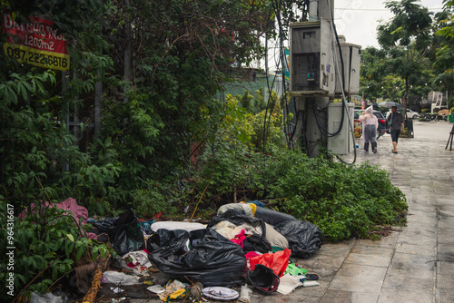 Empty street after it has rained becuse of the monsoon in Vietnam, Asia. The side of the road is filled with plastic bags and hazardous waste making evident the environmental problem Asia faces photo