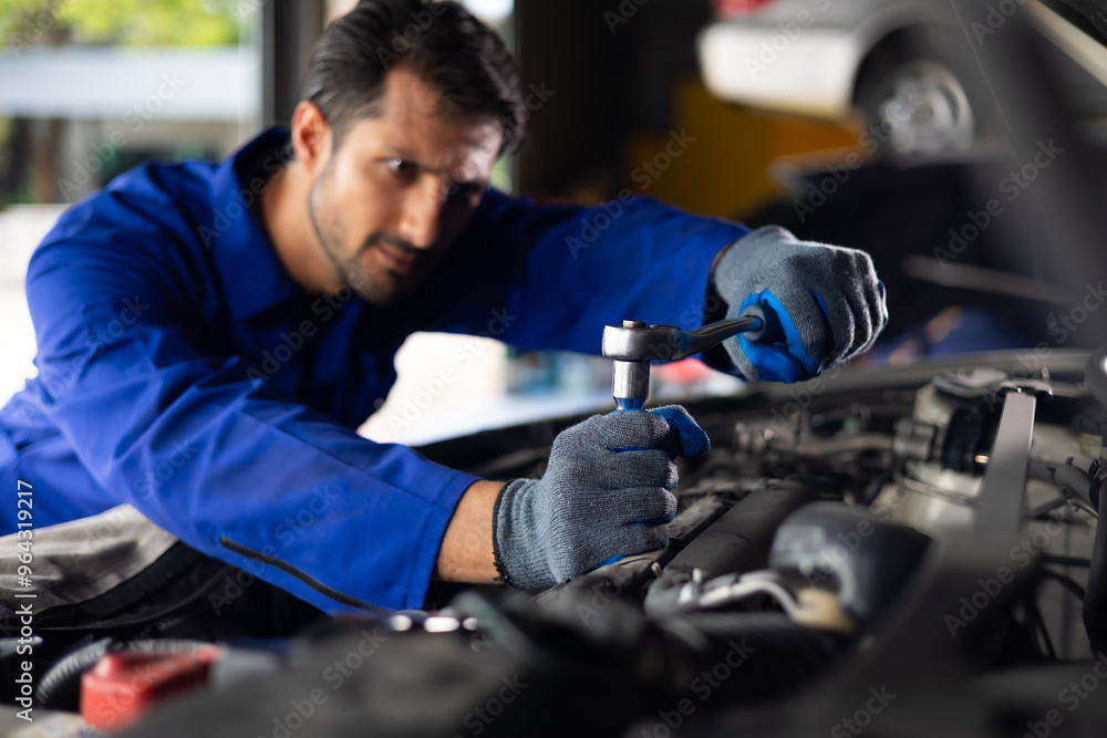 Close up mechanical hand with tools and spanner. Hispanic latin male mechanic repairs car in garage. Car maintenance and auto service garage concept Close up mechanical hand with tools and spanner. Hispanic latin male mechanic repairs car in garage. Car maintenance and auto service garage concept