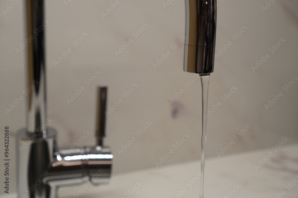 Naklejka premium water flowing from a silver tap