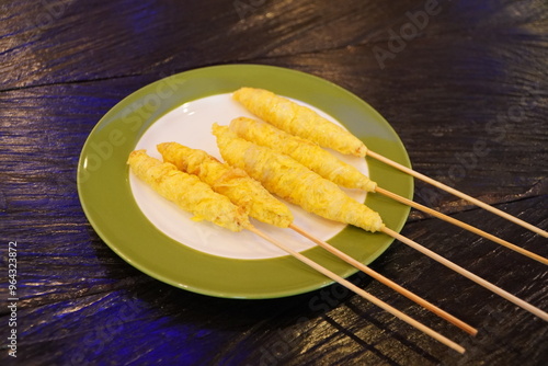 Telor gulung on a plate. Telur gulung or rolled egg is a Indonesian traditional food in which an egg is fried and then rolled using a skewer which is usually made of bamboo. photo