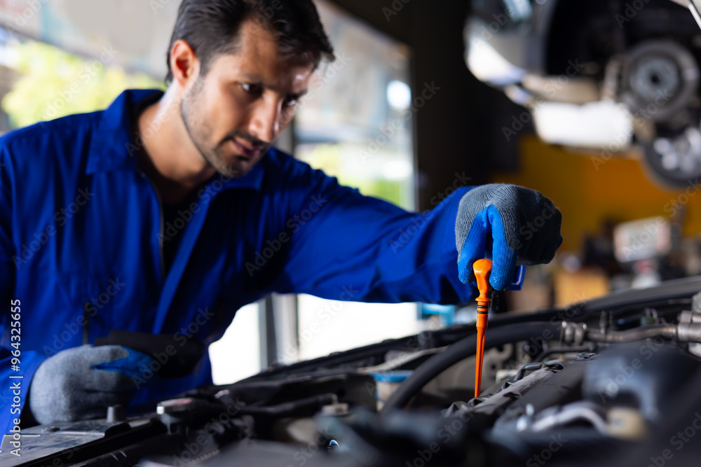 hispanic latin male mechanic repairs car in garage. Closeup hand. Auto car mechanic checking the oil level of the car engine. Car repair and maintenance hispanic latin male mechanic repairs car in garage. Closeup hand. Auto car mechanic checking the oil level of the car engine. Car repair and maintenance
