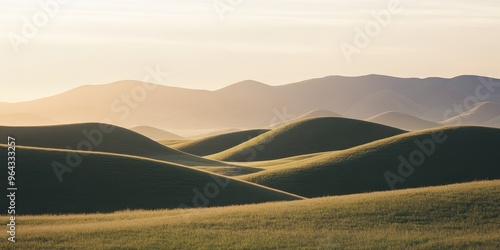 Serene landscape featuring rolling green hills under a soft golden light during sunrise or sunset.