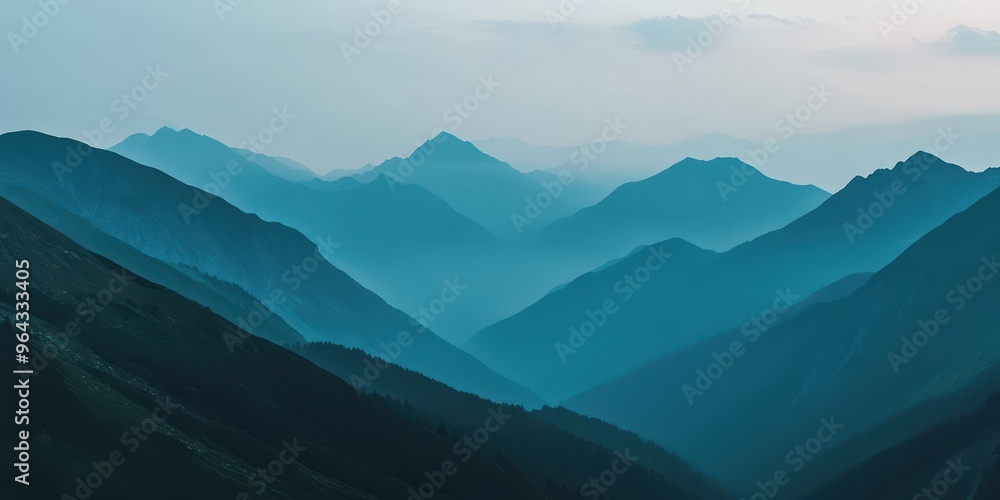Fototapeta premium Serene mountain landscape with layered peaks shrouded in mist, creating a peaceful and tranquil atmosphere in the wilderness.