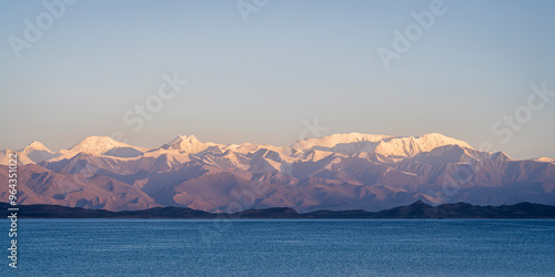 Scenic high altitude landscape panorama of Karakul lake at sunrise, with snow-capped Trans-Alai mountain range, Murghab, Gorno-Badakhshan, Tajikistan Pamir