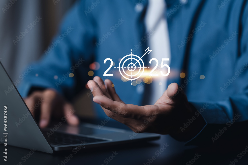 Set goals for 2025. Businessman holds 2025 text with business operations goals. To achieve the goals of a growing business Set goals for 2025. Businessman holds 2025 text with business operations goals. To achieve the goals of a growing business
