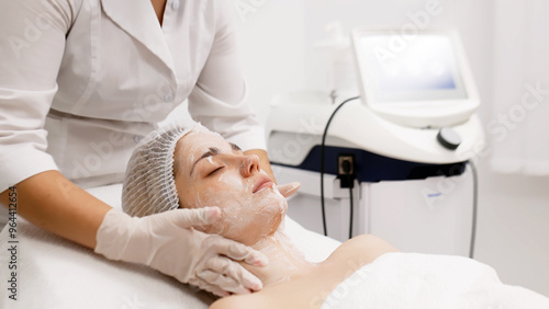 A skilled cosmetologist cleanses a young woman's face with specialized products in a modern beauty salon. This professional treatment promotes radiant skin and rejuvenates your beauty routine.