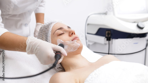 Tableau sur toile A cosmetologist performs RF lifting and ultrasound facial tightening in a modern salon