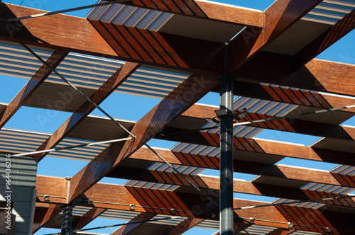 Sunlight shining through wooden beams and translucent panels creates captivating geometric patterns in modern building blending with nature