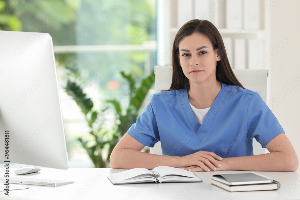 Portrait of beautiful nurse at table in hospital office Portrait of beautiful nurse at table in hospital office