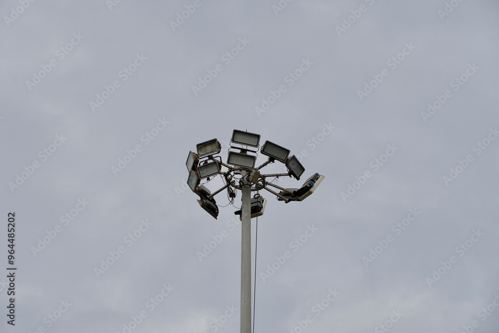 High mast lighting pole lights. Round sport light with white cloud sky background. High mast lighting pole lights. Round sport light with white cloud sky background.