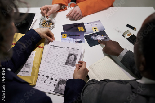 Konstfotografi Investigators examining criminal profiles and evidence at desk filled with photos, papers, and tools