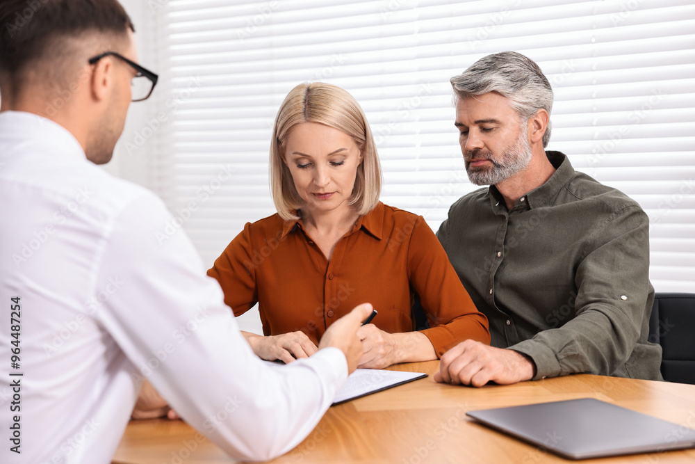 Pension plan. Couple consulting with insurance agent at table indoors Pension plan. Couple consulting with insurance agent at table indoors