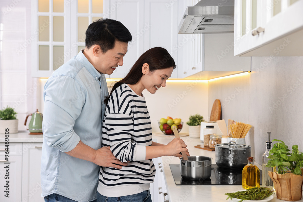 Happy lovely couple cooking together in kitchen Happy lovely couple cooking together in kitchen