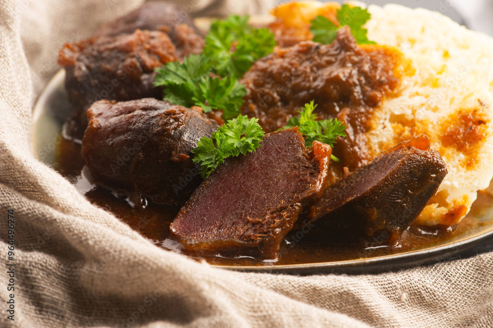 Stewed goose stomach. Traditional Polish meat on a dark background. Stewed goose stomach. Traditional Polish meat on a dark background.