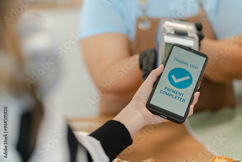 Woman Using Mobile Phone Payment to Transfer Money to bakery Shop Seller.NFC QR code device,payWave,contactless payment code for fast digital transaction,Online banking app on mobile phone,paperless photo