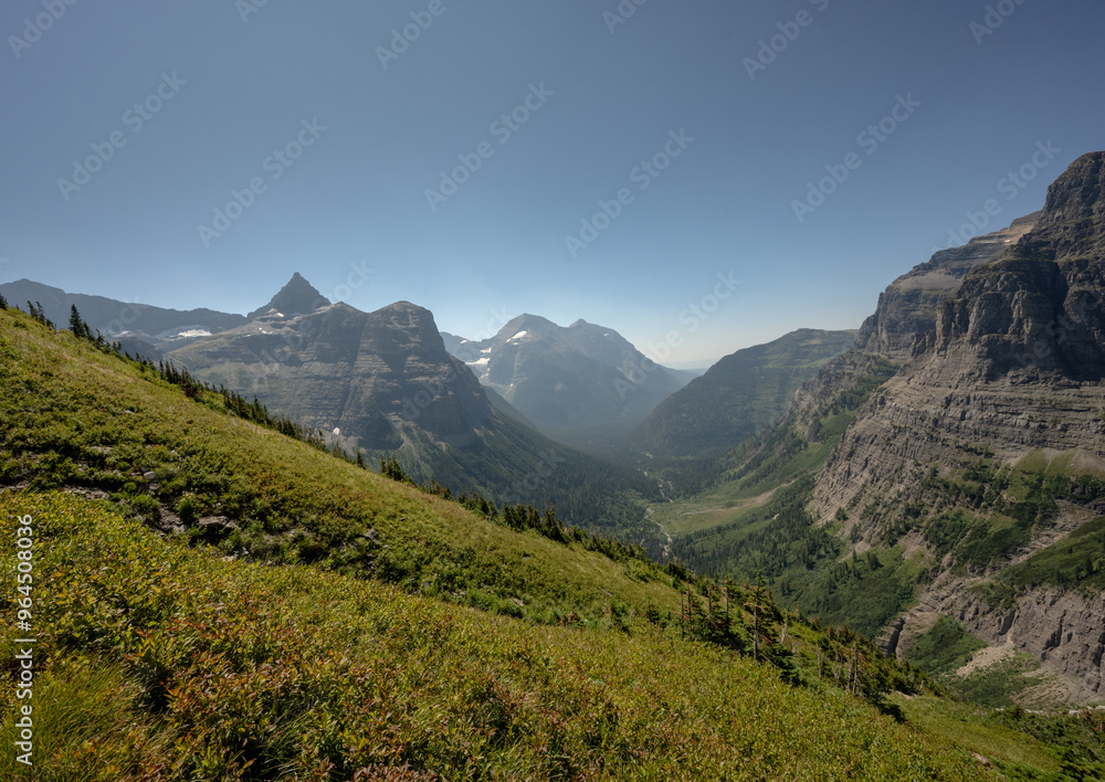 Obraz premium Bowman Creek Runs At The Bottom Of The Valley Below Thunderbird Mountain and Boulder Pass