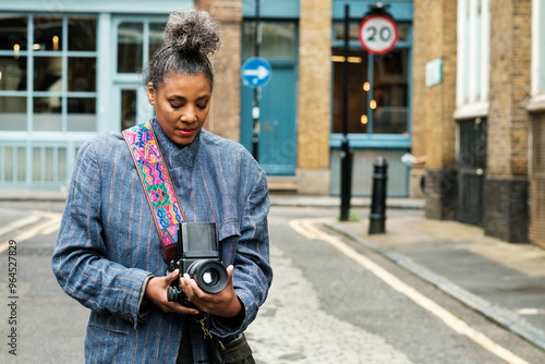 Canvas Print Portrait of mature woman photographer looking through a film camera