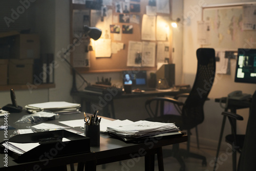 Fotografi Investigating setting in dimly lit office with papers scattered on desk and bull