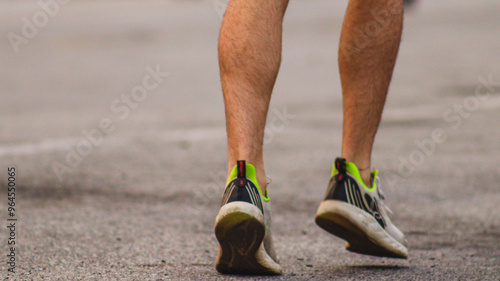 perna de um corredor em movimento na rua, capturando a velocidade e energia de uma corrida ao ar livre em uma manhã ensolarada photo