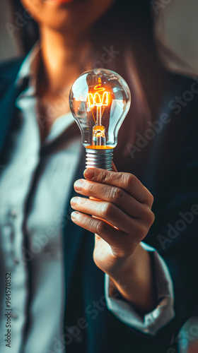 business woman hand proudly holds a lighted idea bulb