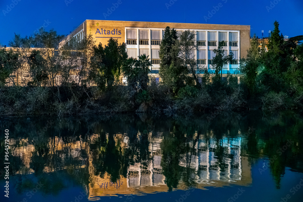 Obraz premium Seville, Spain, Jan 12 2017, Old Tobacco Factory Reflected in Guadalquivir River at Night