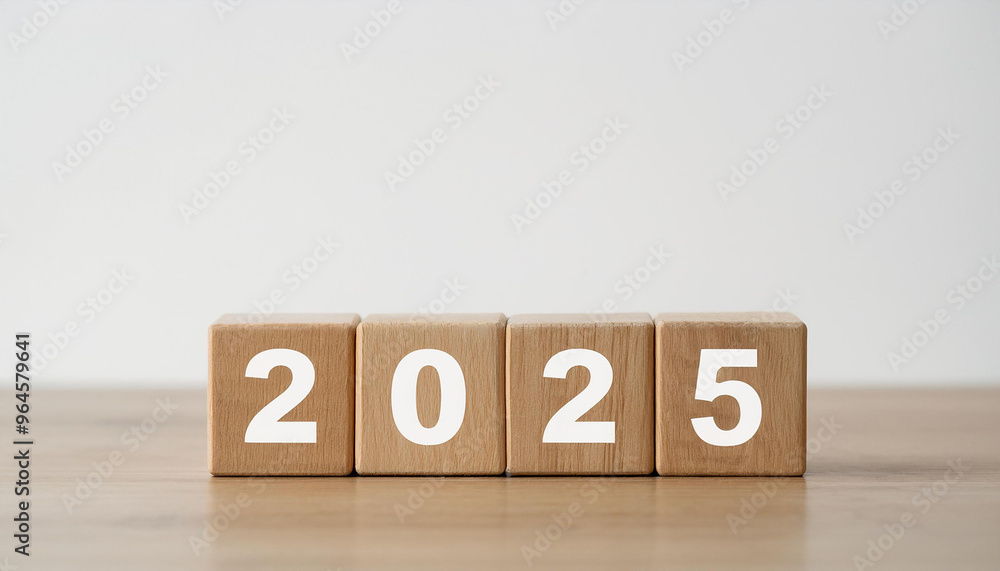Wooden cubes with number 2025 on wooden table, white wall. New Year.