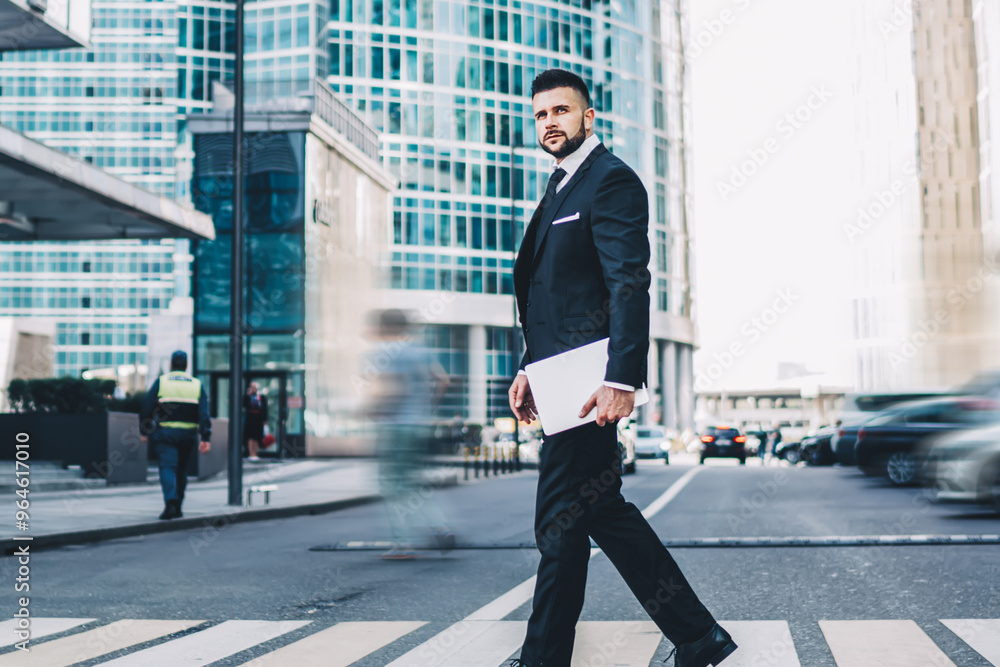 Serious man crossing road in downtown looking around about cars caring for own safety, confident male trader with modern netbook getting in time to big enterprise conference in Manhattan city Serious man crossing road in downtown looking around about cars caring for own safety, confident male trader with modern netbook getting in time to big enterprise conference in Manhattan city