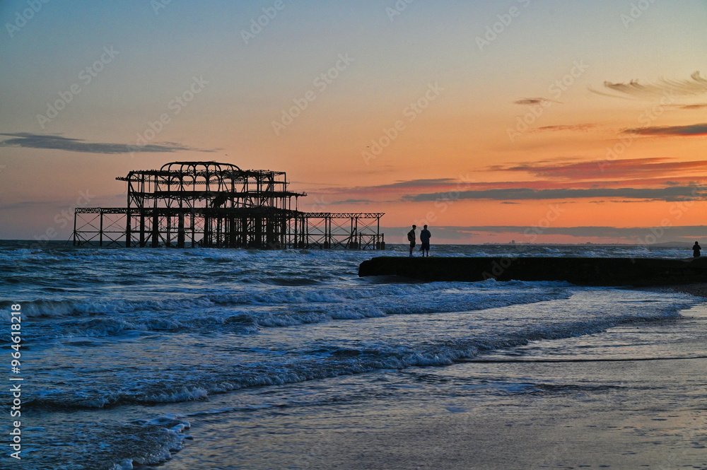 Obraz premium Remains of the West Pier on the beach of the English city of Brighton, while sunset 