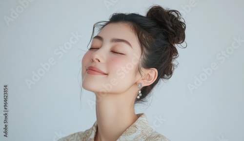 A young Asian girl, eyes softly shut, exudes a sense of peaceful joy in a moment of calm reflection, embodying tranquility and relaxation.