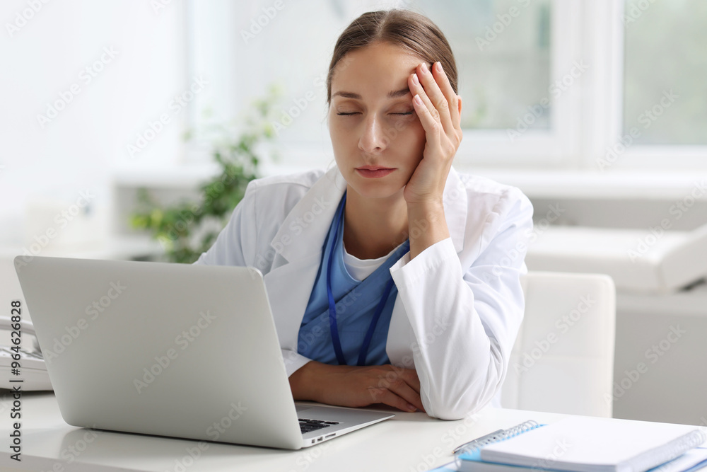 Tired nurse sleeping at white table in clinic Tired nurse sleeping at white table in clinic