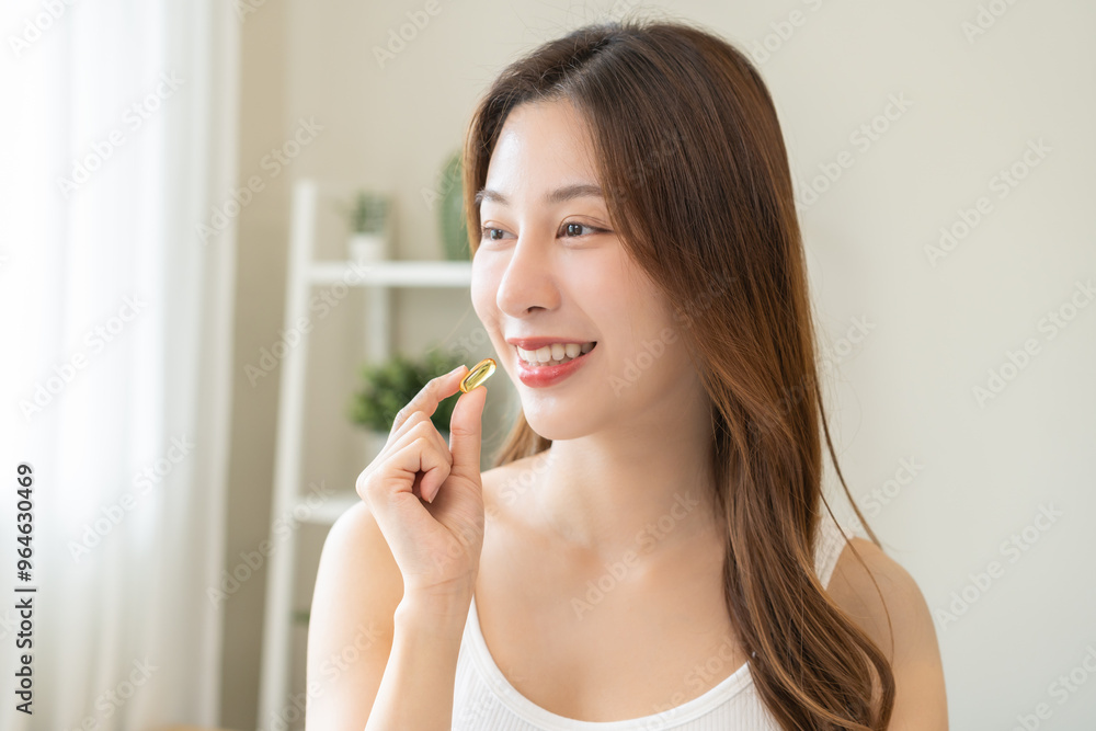 Dietary supplement, asian young woman, girl hand holding medical pill capsule, take or eat vitamin C, D for treatment for skin, hair and nail strengthen with glass of pure water at home, healthcare. Dietary supplement, asian young woman, girl hand holding medical pill capsule, take or eat vitamin C, D for treatment for skin, hair and nail strengthen with glass of pure water at home, healthcare.