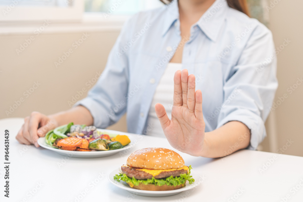 Diet concept, asian young woman hand reject eat burger, hamburger on plate, push out or deny to eat fast, junk food choose green vegetable salad, girl eat low fat for good healthy, getting weight loss Diet concept, asian young woman hand reject eat burger, hamburger on plate, push out or deny to eat fast, junk food choose green vegetable salad, girl eat low fat for good healthy, getting weight loss