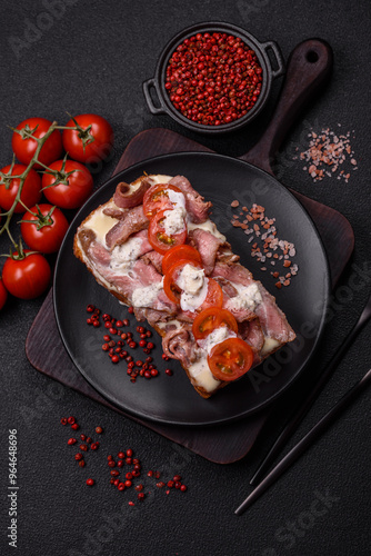 Sandwich with brioche bun, roast beef, tomatoes, stracciatello photo