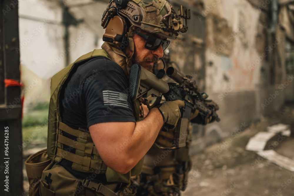 Fototapeta premium Close up of brave soldier with rifle in a mission on a battlefield.