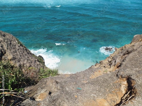 a rock cliff with waves crashing on the shore, Cliff overlooking beach, senggigi beach, Beach in West Nusa Tenggara photo