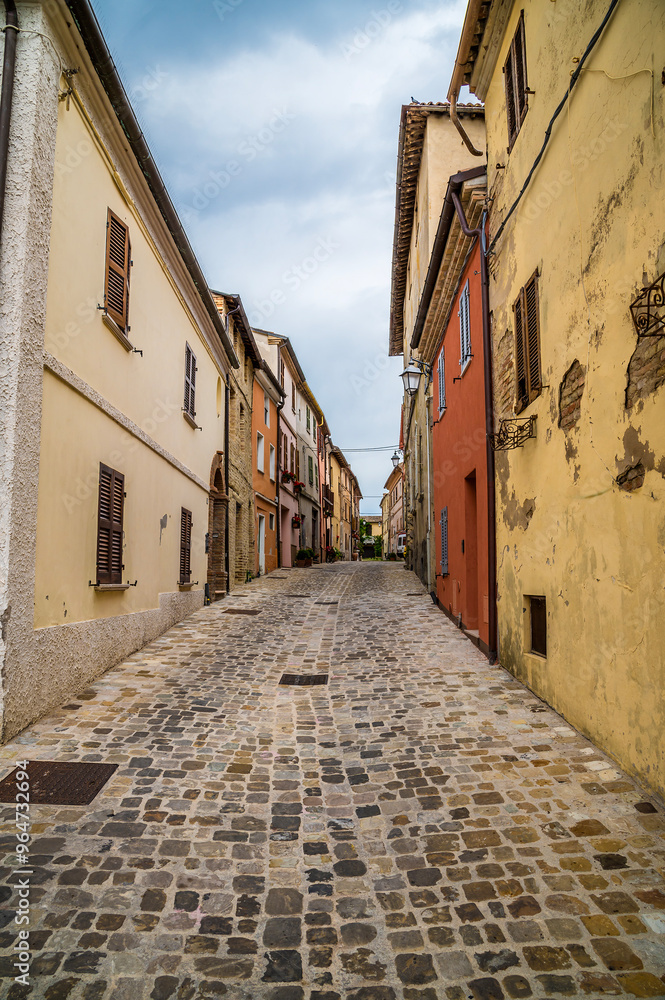 Fototapeta premium A view up a quiet street in the hilltop fortress village of Sant Andrea di Suasa, Italy in summertime