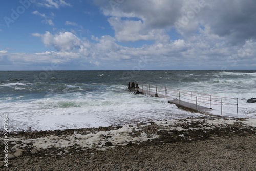 Wellen brechen an einem Steg am Strand Solviken in Mölle auf der Kullen Halbinsel in der schwedischen Provinz Skane. Von dort am Öresund führt ein Wanderweg zum Leuchtturm Kullen. 