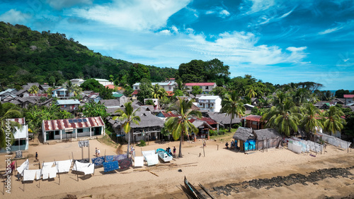 Aerial view of Nosy Komba Island in Madagascar showcasing vibrant local life, lush greenery, and sandy shores during a sunny day photo