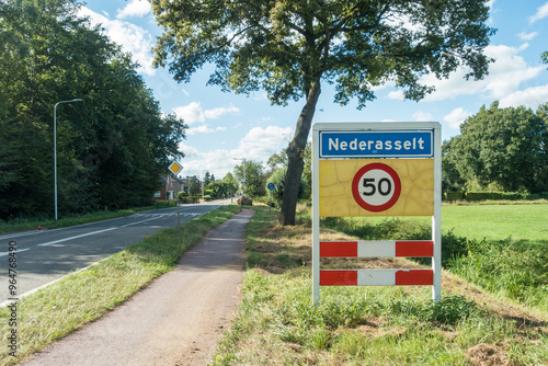 Place name sign of the village of Nederasselt, the Netherlands, with speed limit sign for 50 km per hour