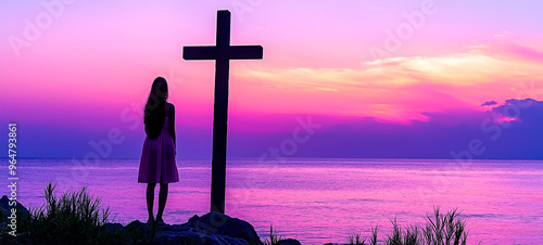 Silhouette of young woman by cross against colorful sunset sky. Concept of faith and Cristianity. photo