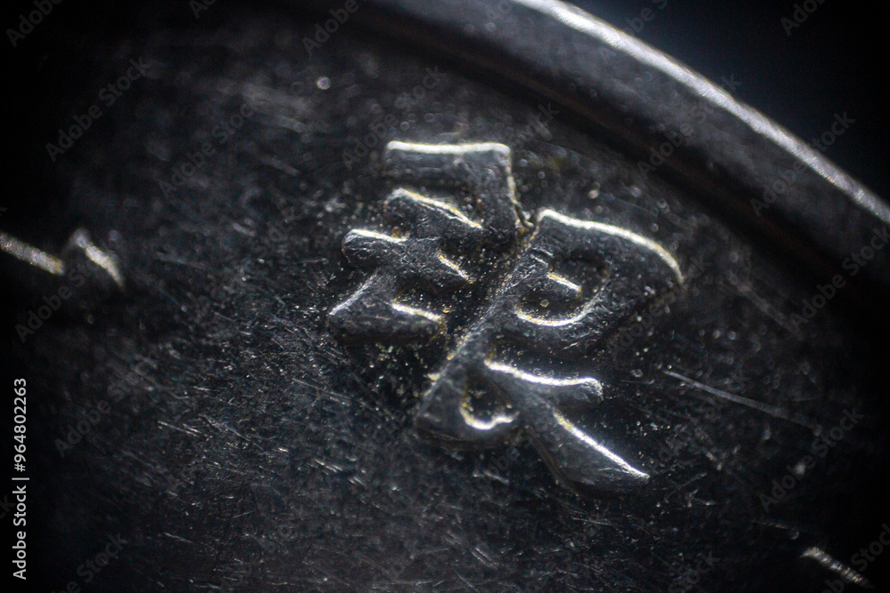 Fototapeta premium Chinese characters engraved on a coin in close-up 