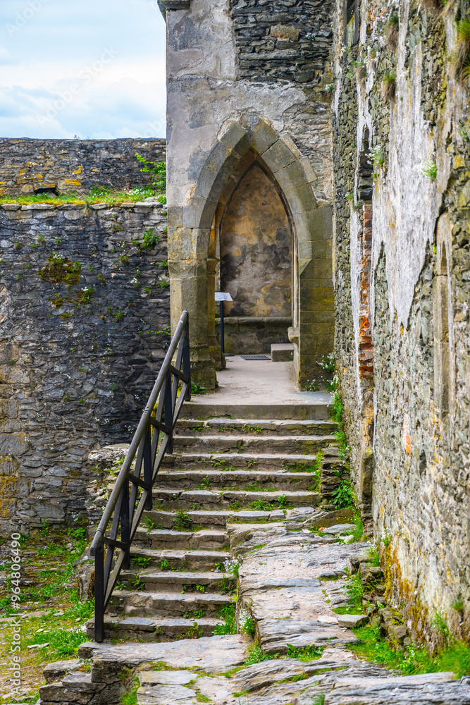 Ancient stone stairs lead upward through the walls of Bezdez Castle, surrounded by weathered stones and vibrant greenery, evoking a sense of history and mystery in Czechia. Ancient stone stairs lead upward through the walls of Bezdez Castle, surrounded by weathered stones and vibrant greenery, evoking a sense of history and mystery in Czechia.