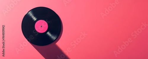 Vinyl record on pink background with long shadow, retro music concept