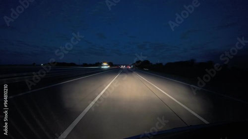 Timelaps of a car driving on a german highway during blue hour at night, headlights lights up die road,summer day