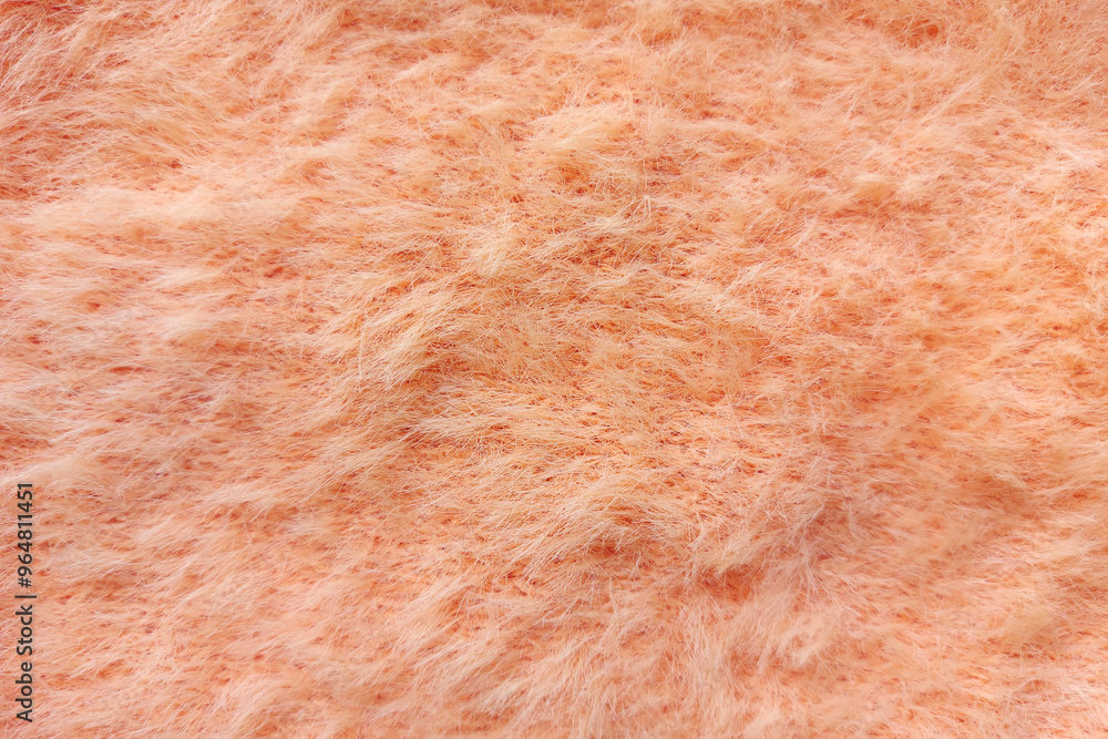 Fototapeta premium Peach plush knitted fabric texture close up. Fluffy and soft cozy fabric background. 