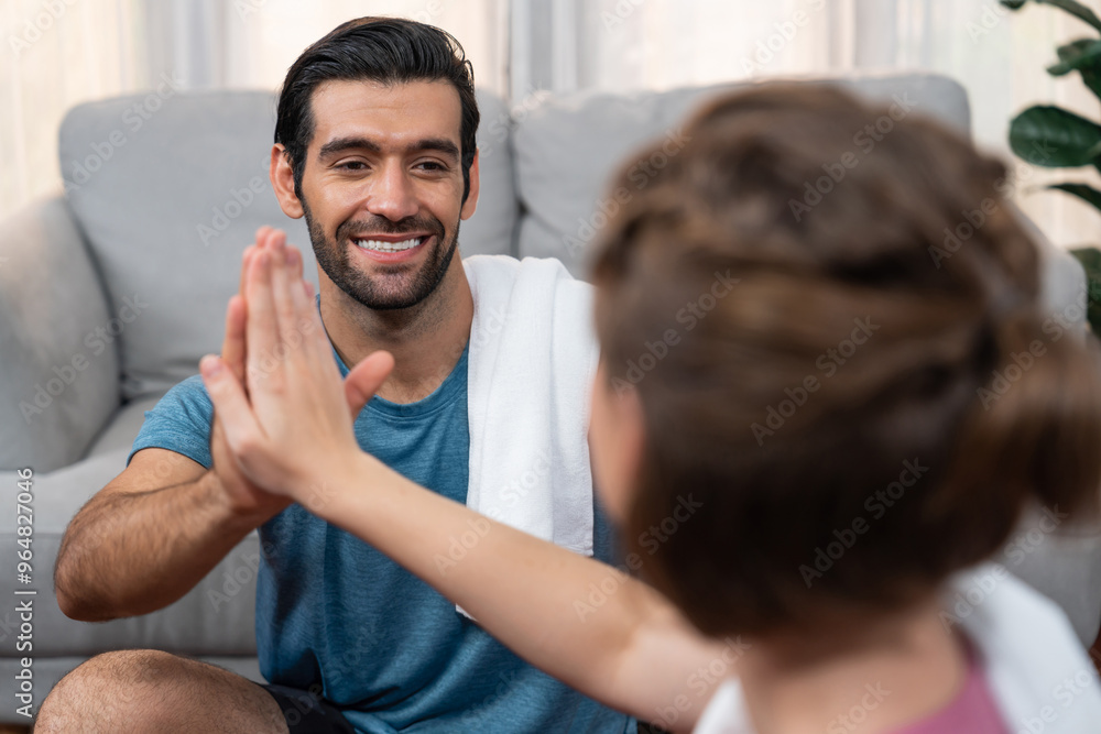 Fototapeta premium Athletic body and sporty young couple or workout buddy in sportswear high five after successful in home workout exercise at gaiety home exercise and healthy lifestyle concept.