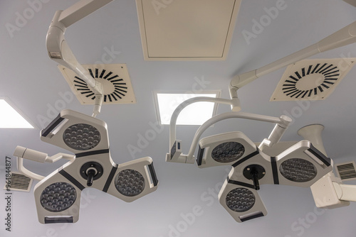 Two surgical lamps in operation room.Useful file for your hospital brochure, medical article and other purpose. Closeup low angle view of operating room lighting photo