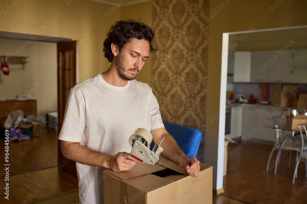 A person is packing a moving box in a cozy, inviting, and comfortable home setting A person is packing a moving box in a cozy, inviting, and comfortable home setting