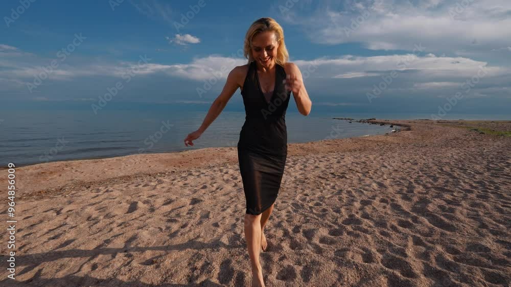 Young happy woman in black dress running on lake shore on summer day, slow motion Young happy woman in black dress running on lake shore on summer day, slow motion