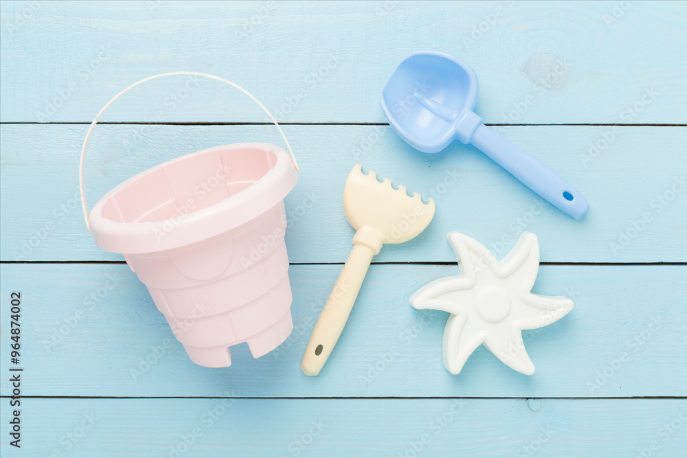 Cute toys for playing with sand on wooden background, top view